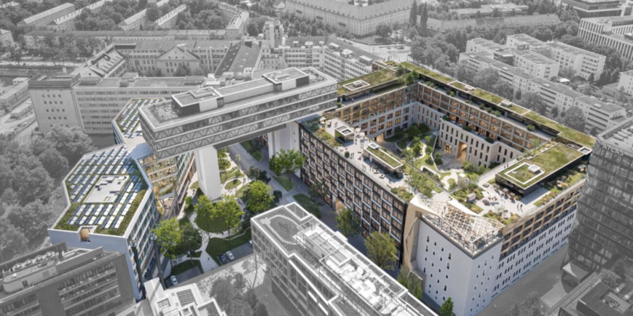 Luftaufnahme eines modernen Bürokomplexes mit begrüntem Innenhof und Dachgärten in der Stadt.